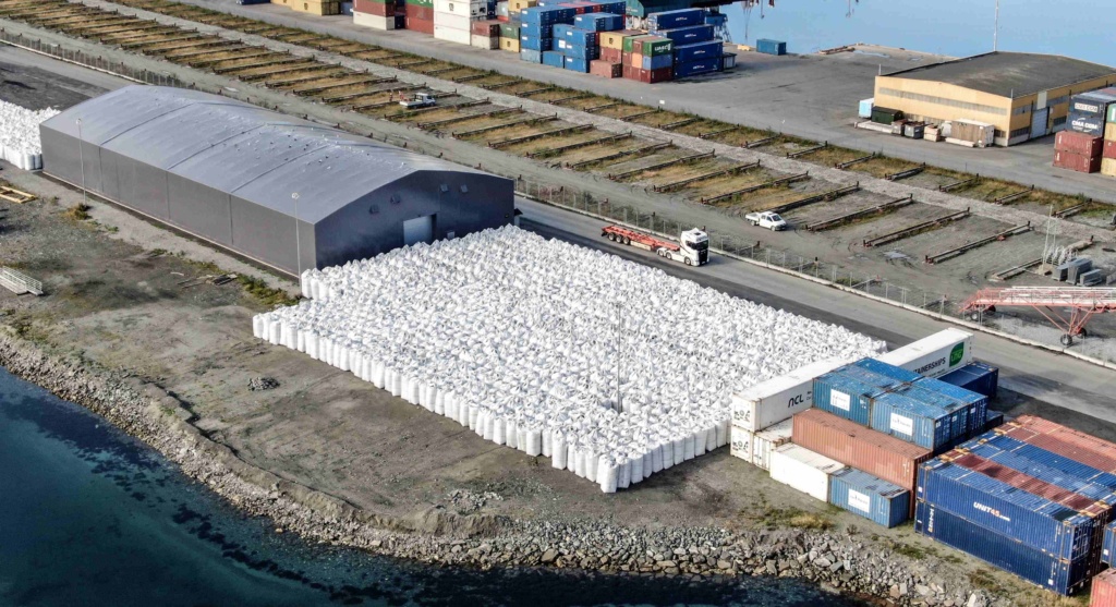 Lagerområde med hall og containere ved sjøkanten